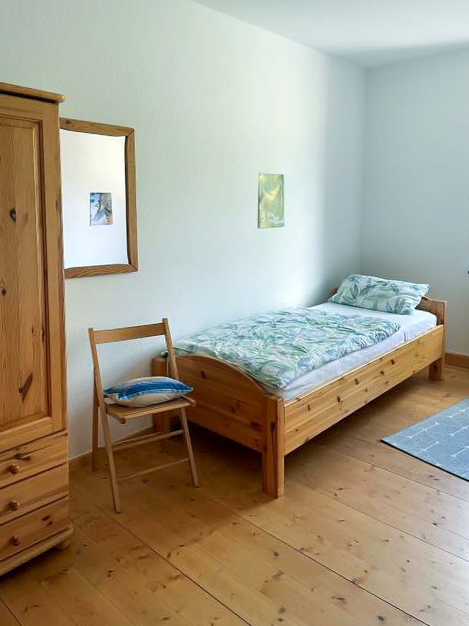 Einzelbett mit Stuhl und Schrank